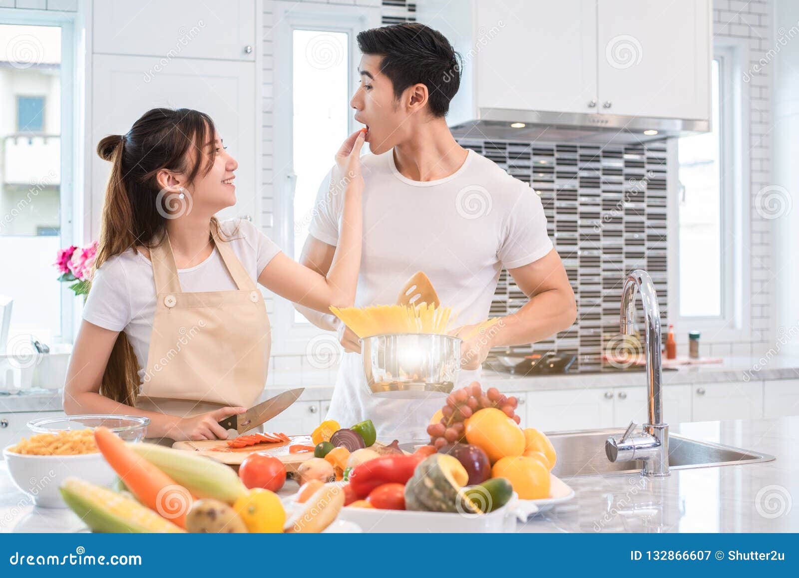 asian couples feeding food together in kitchen. people and lifestyles concept. sweet honeymoon and holidays concept. valentines d