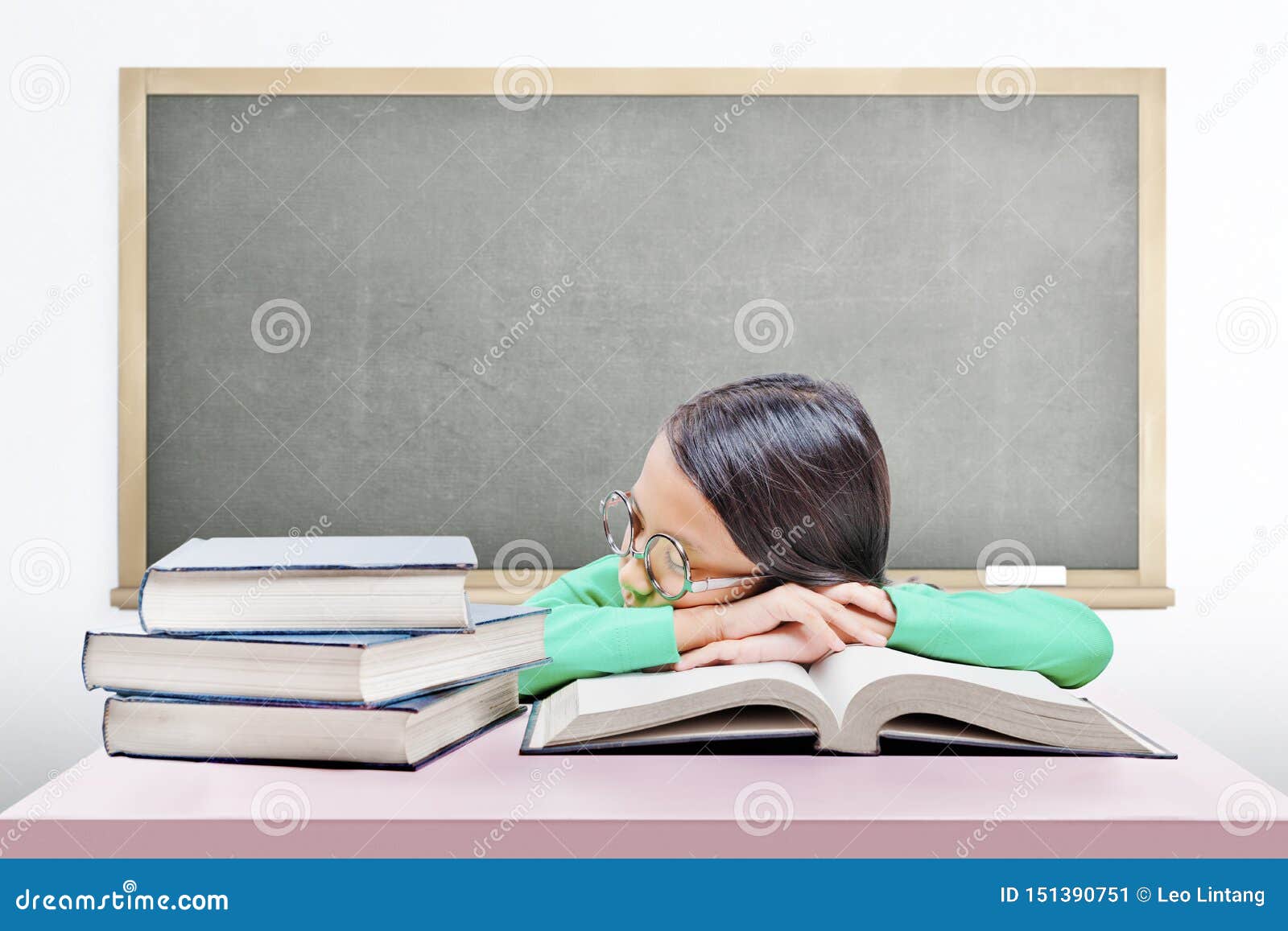 Asian Cute Girl With Glasses Fall Asleep On Book On The Desk Stock
