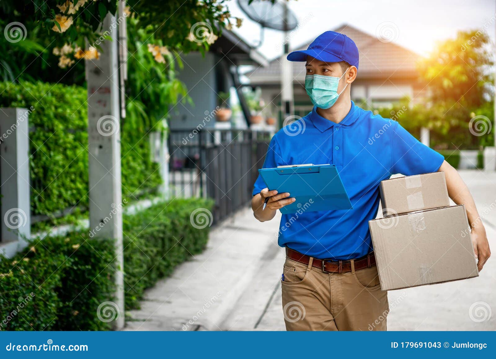 asian delivery man in blue t-shirt carrying parcel box