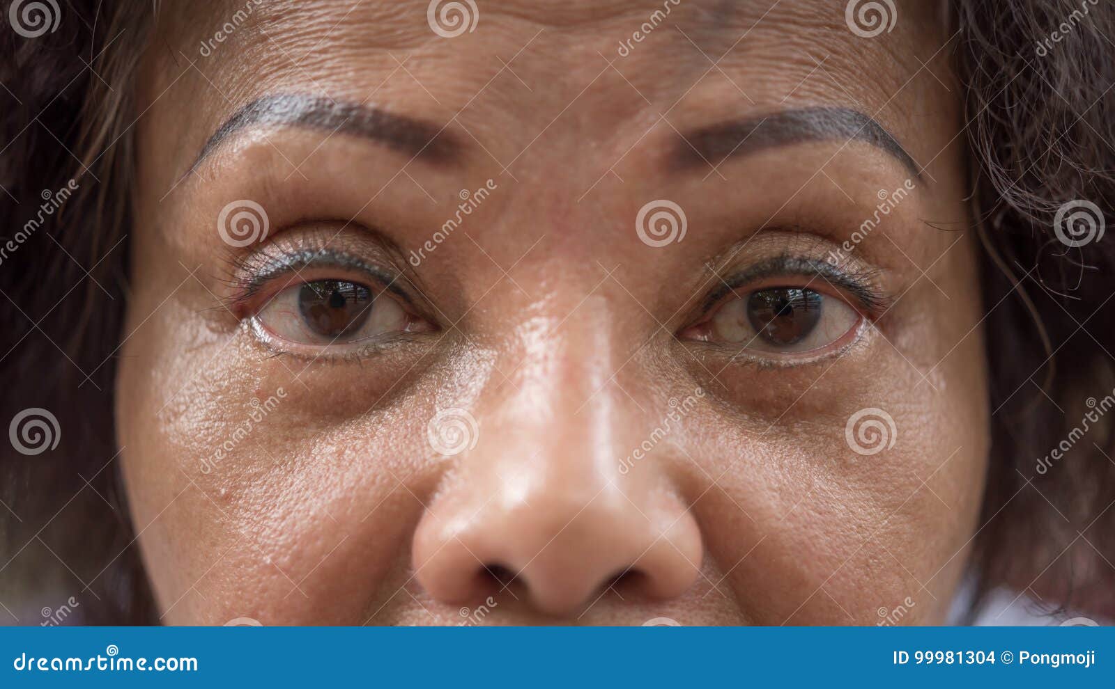 asian elder women show her eyes and eyebrow tattoo