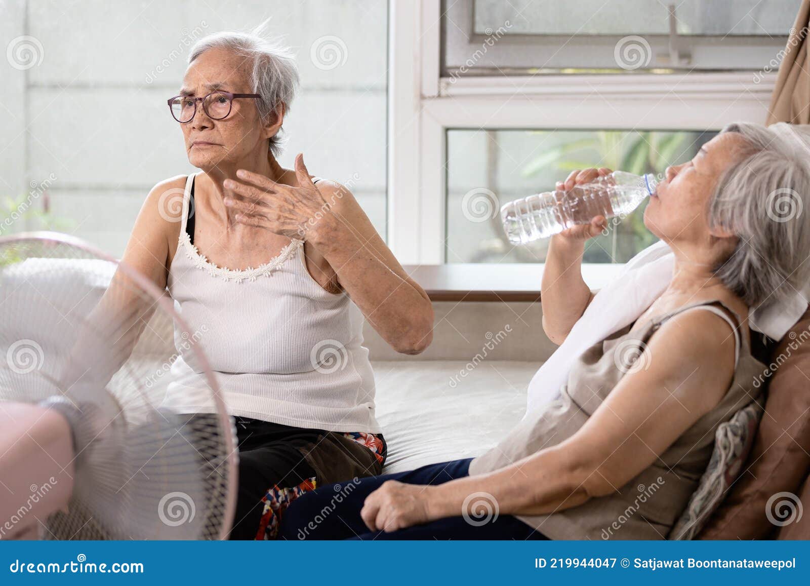 asian elderly people who are hot and thirsty from high temperature heat waves,drinking water help to reduce body heat,prevent heat