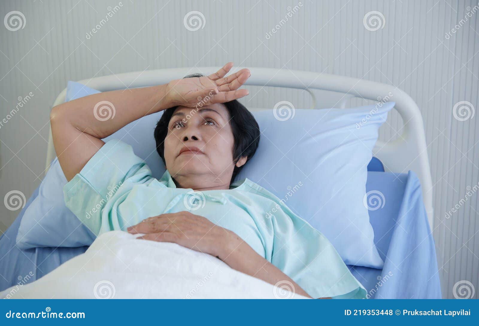 asian elderly woman putting her hand on her forehead with anxious and stress expression face at hospital bed