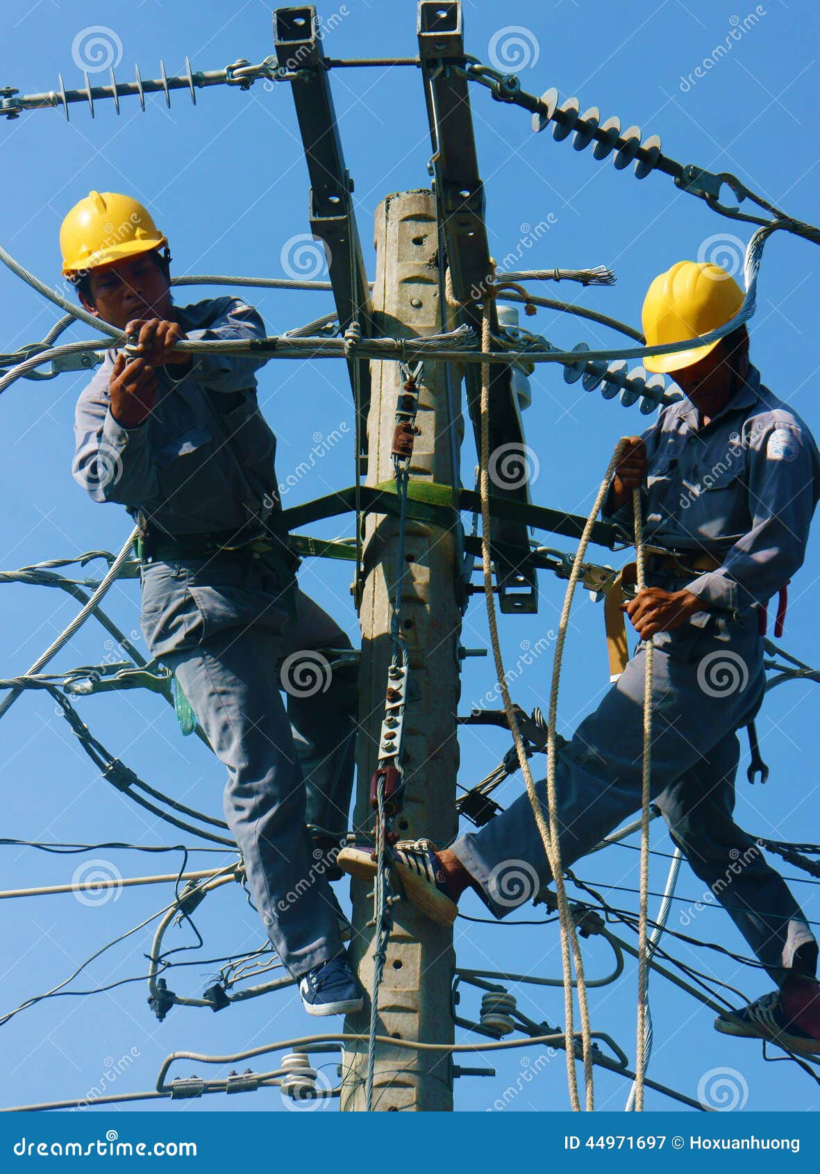 Asian Electrician Climb High, Work on Electric Pole Editorial