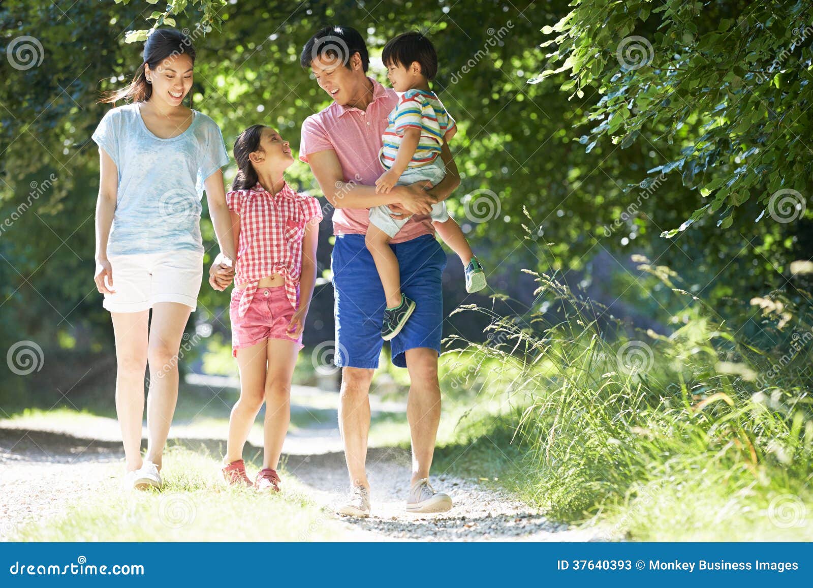 asian family enjoying walk in countryside