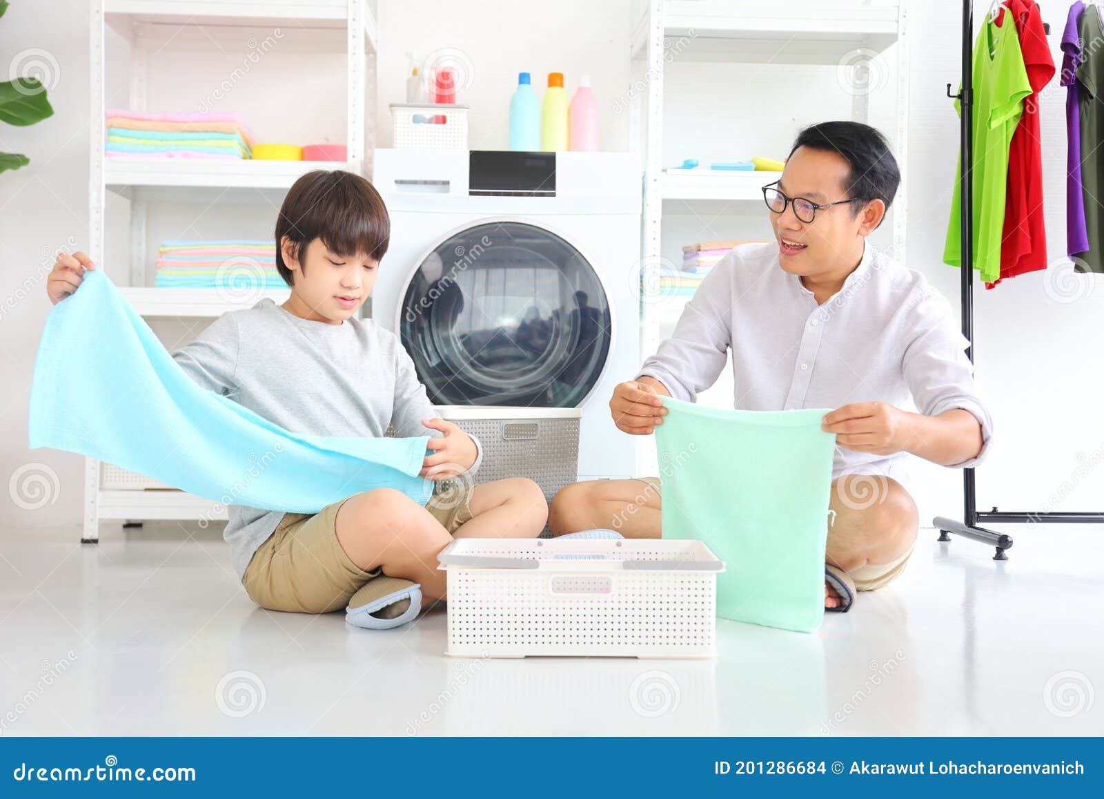 asian father and  son help each other doing laundry together for daily chores