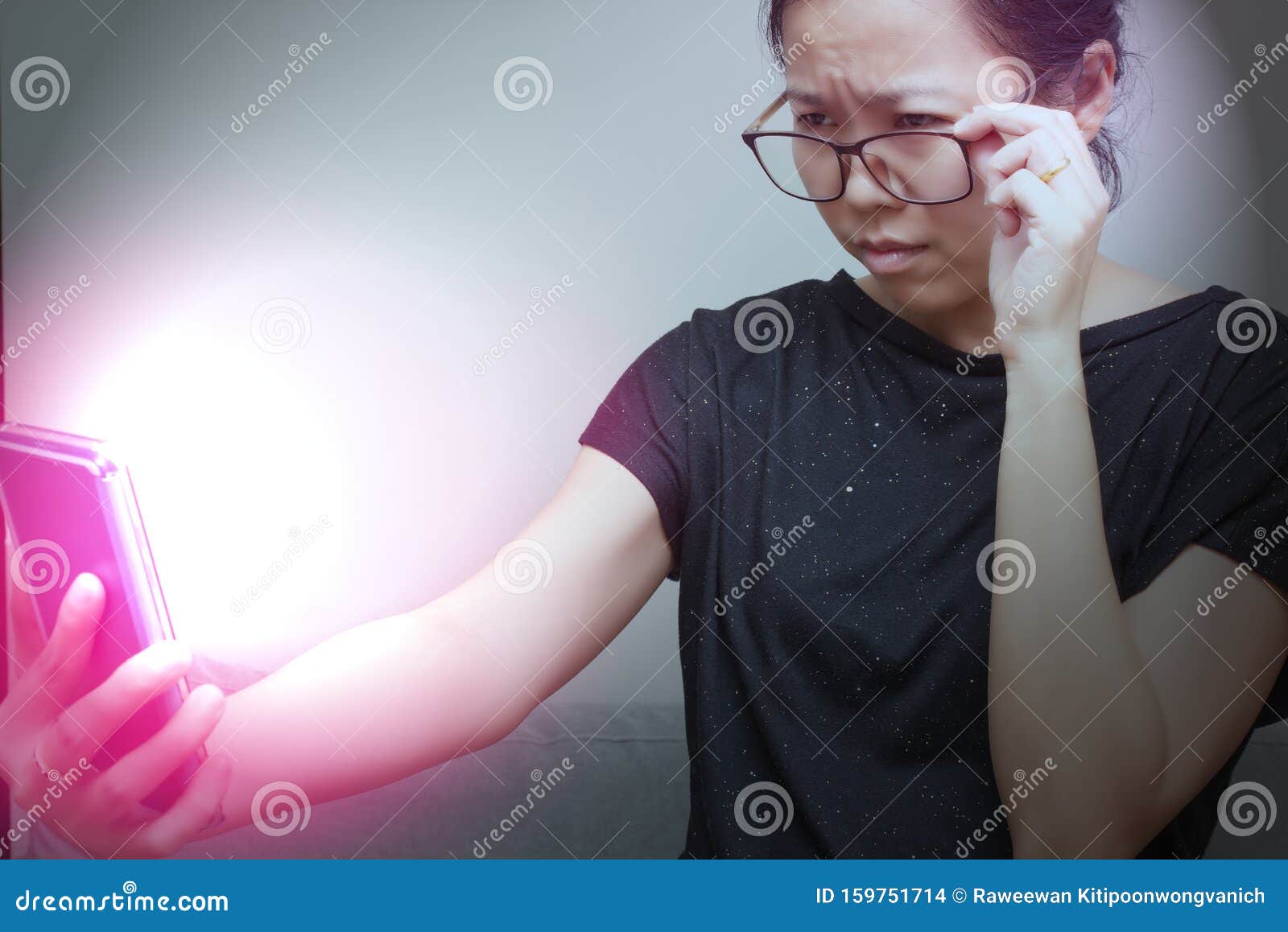 asian female trying to read something in her mobile phone with red spot on her hand. poor sight, farsightedness, myopia