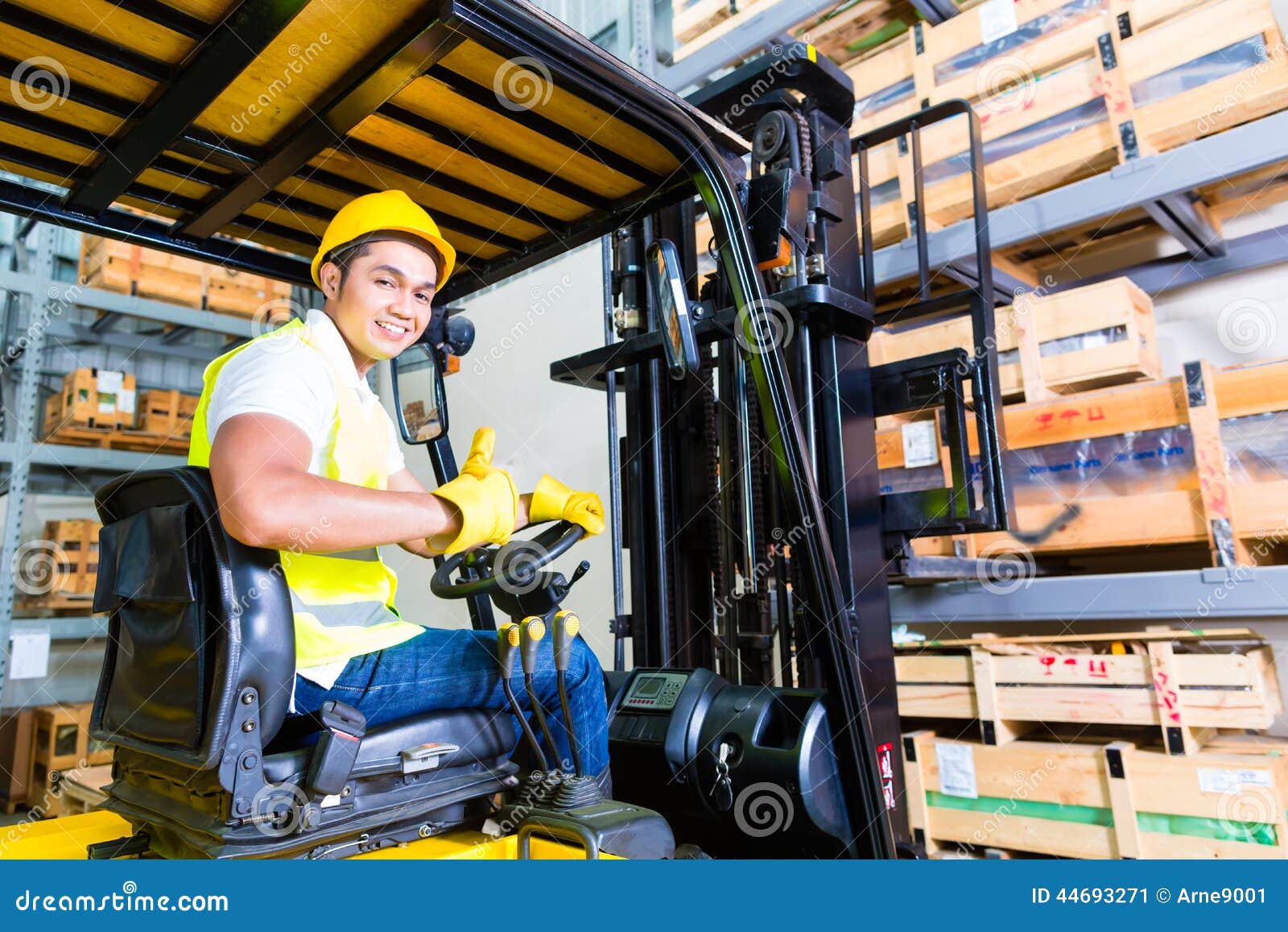 asian fork lift truck driver lifting pallet in storage