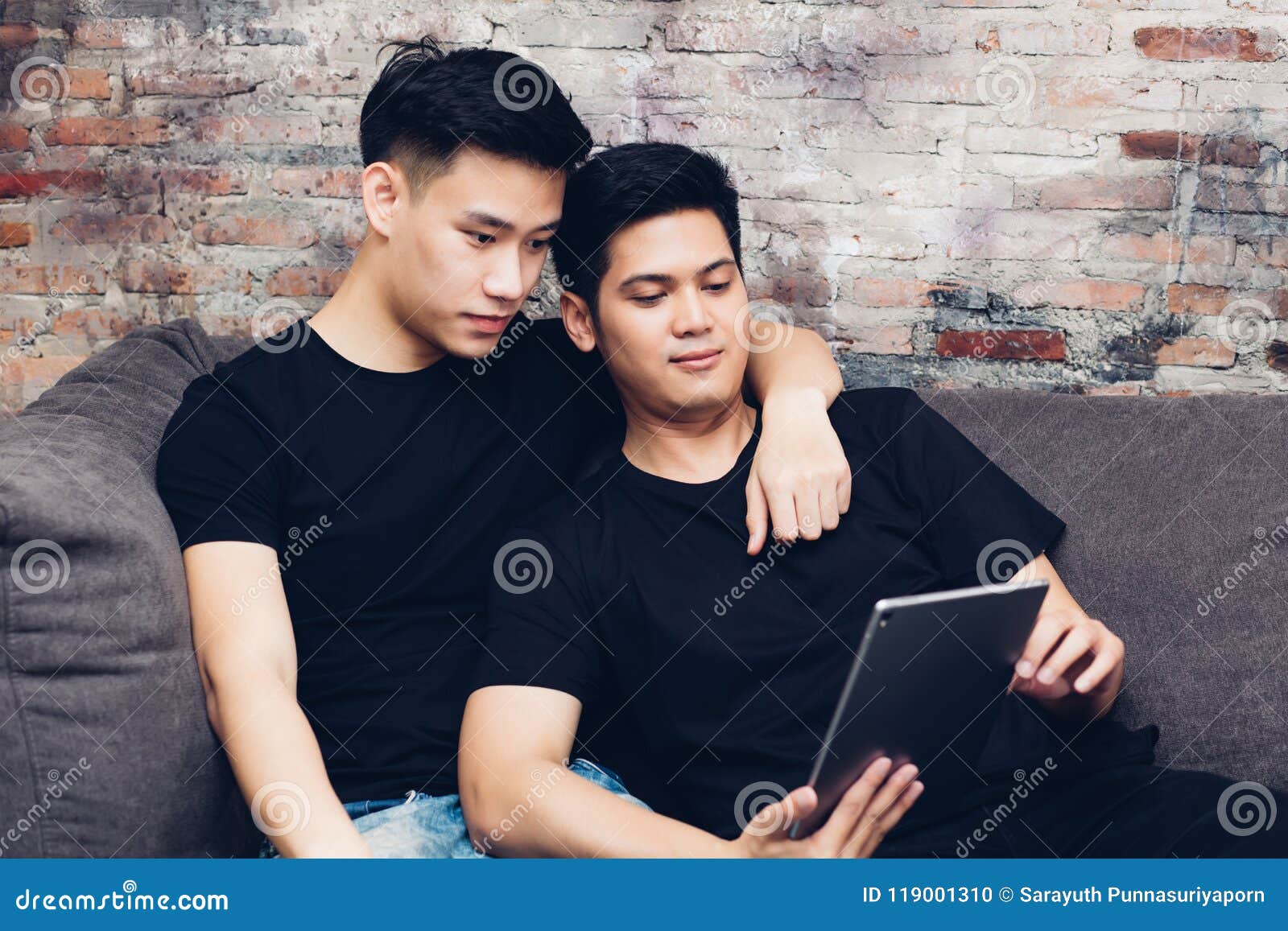 Asian Gay Couple Watching And Looking At Phone Tablet Together Portrait Of Happy Gay Men 
