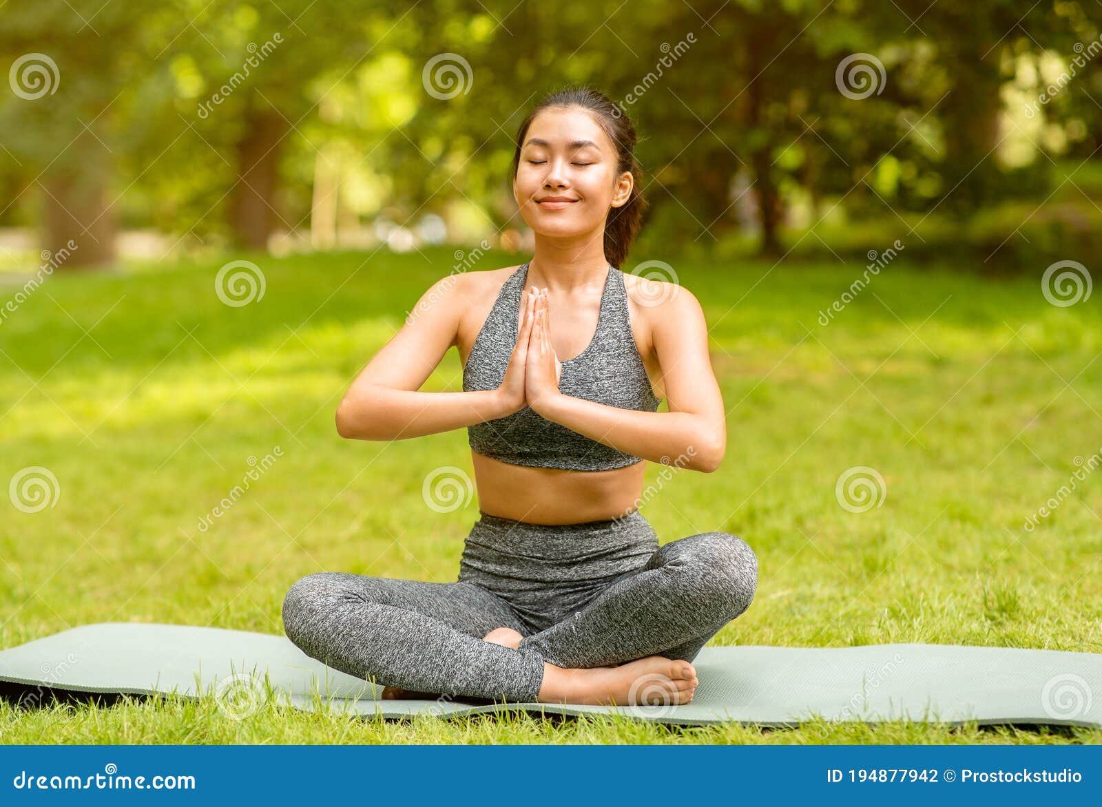 Asian Girl Sitting In Lotus Pose And Doing Yoga Meditation Or Breathing