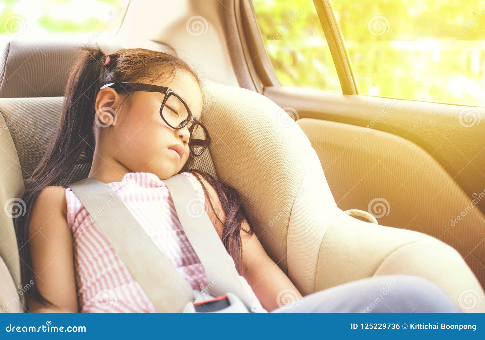 girl sleeping in child car seat.