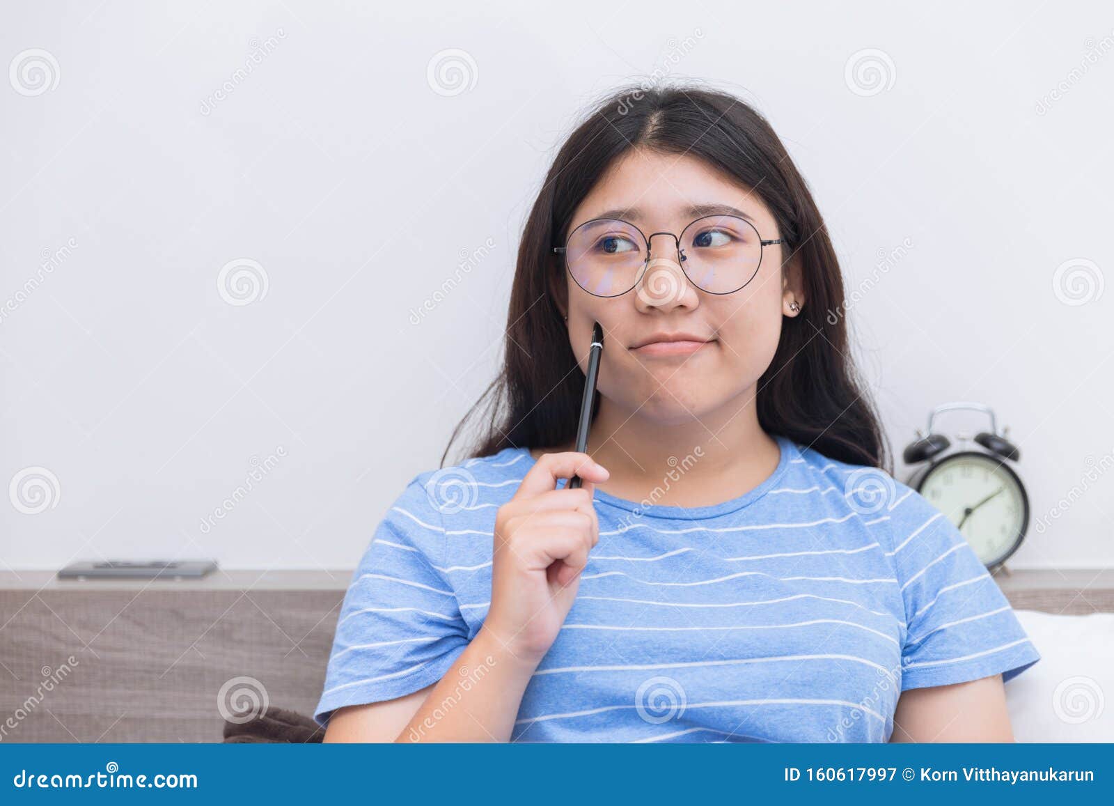 Asian Girl Teen Nerd Glasses Thinking Homework at Home Indoor Stock ... image