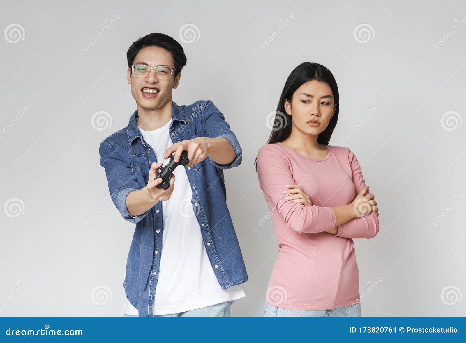 Asian man fun playing video games console with his girlfriend