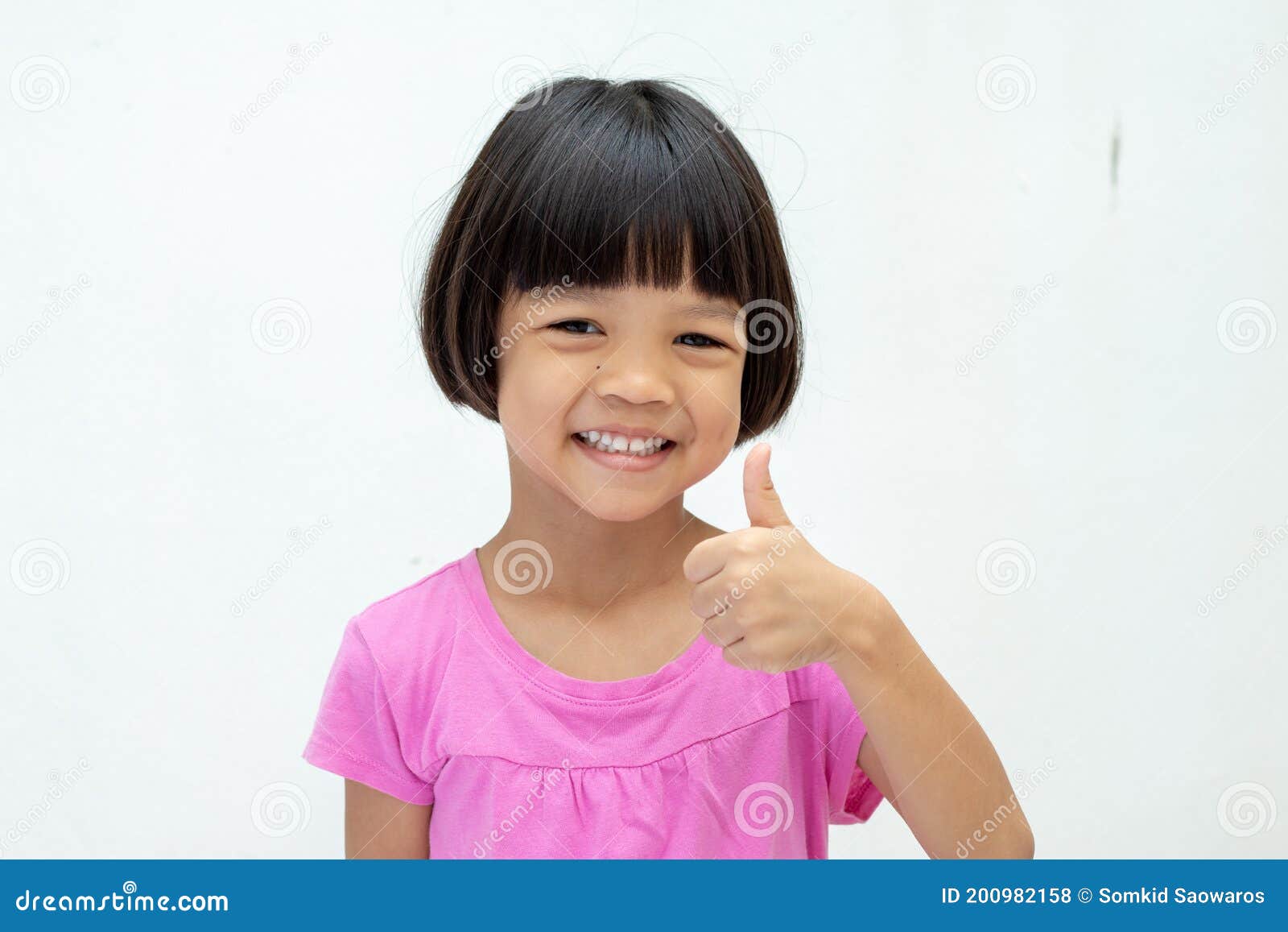 Asian Kid Girl Aged 4 To 6 Years Old with Short Hair, Cute Face and Smiling  Smile. Wear a Pink Shirt Raises the Right Hand and Stock Photo - Image of  people, pink: 200982158