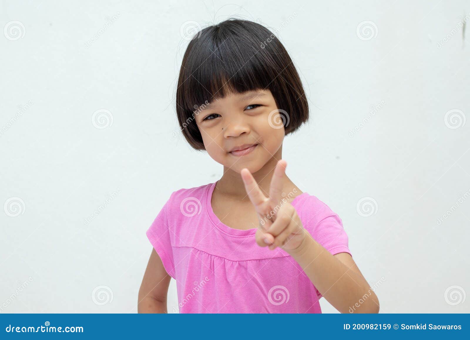 Asian Kid Girl Aged 4 To 6 Years Old with Short Hair, Cute Face and Smiling  Smile. Wear a Pink Shirt Raises the Right Hand and Stock Image - Image of  adorable, face: 200982159