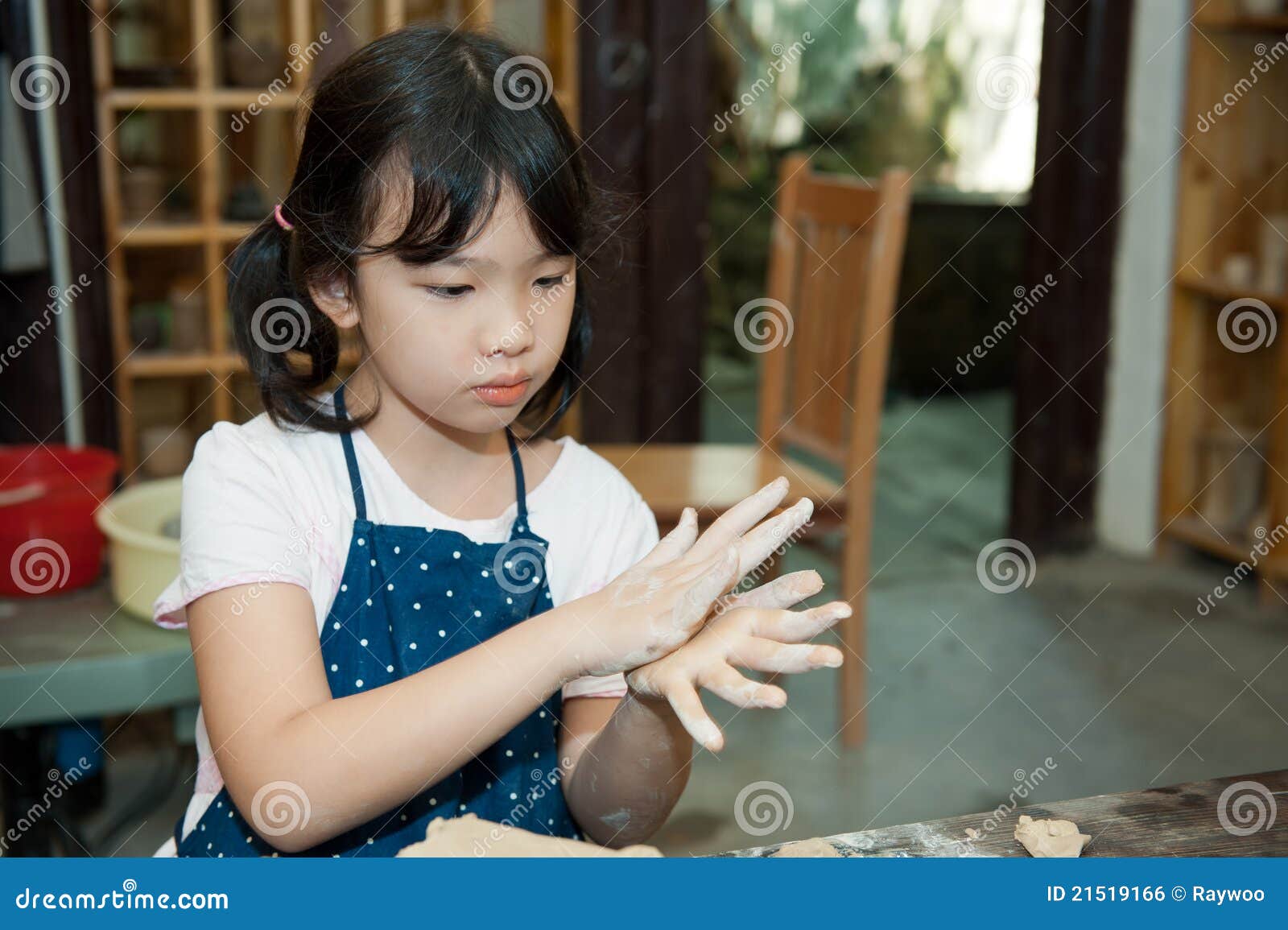 asian kid shaping pottery