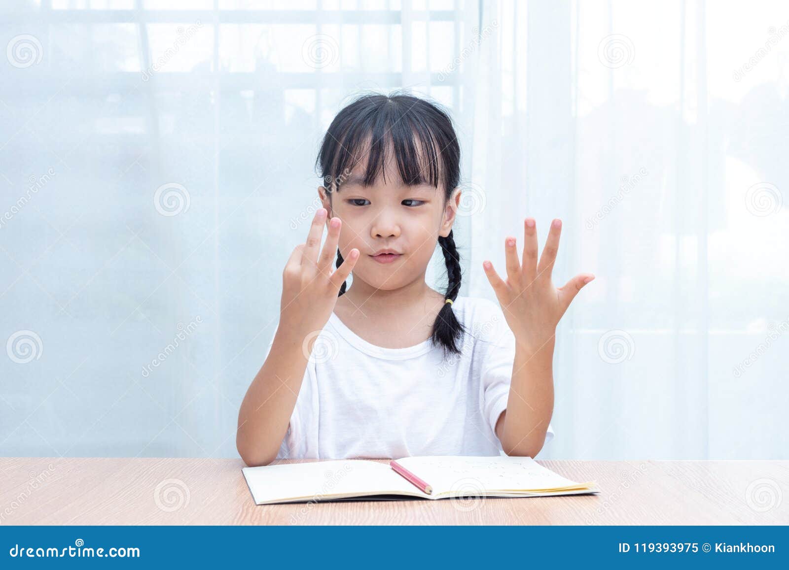 asian little chinese girl doing mathematics by counting fingers