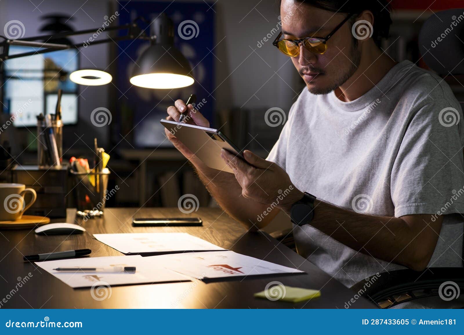 asian man graphic er working on computer drawing sketches logo .