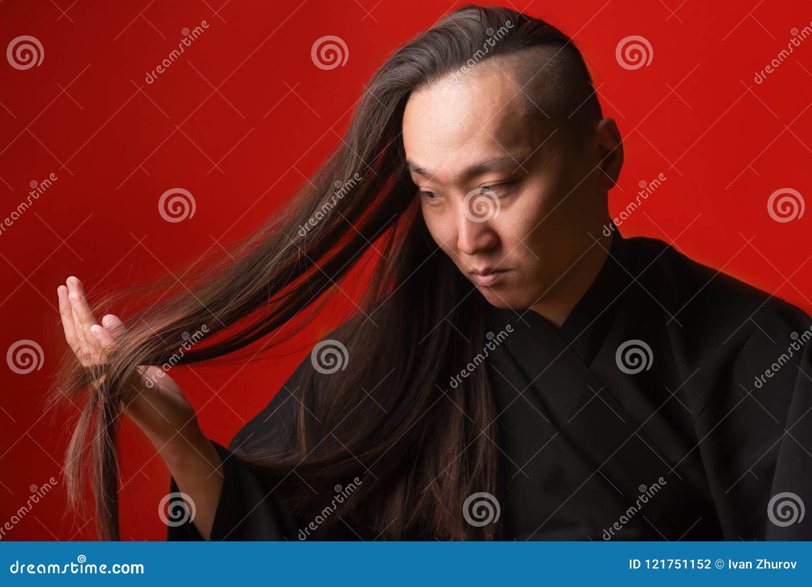 asian man with long thick hair on a red background