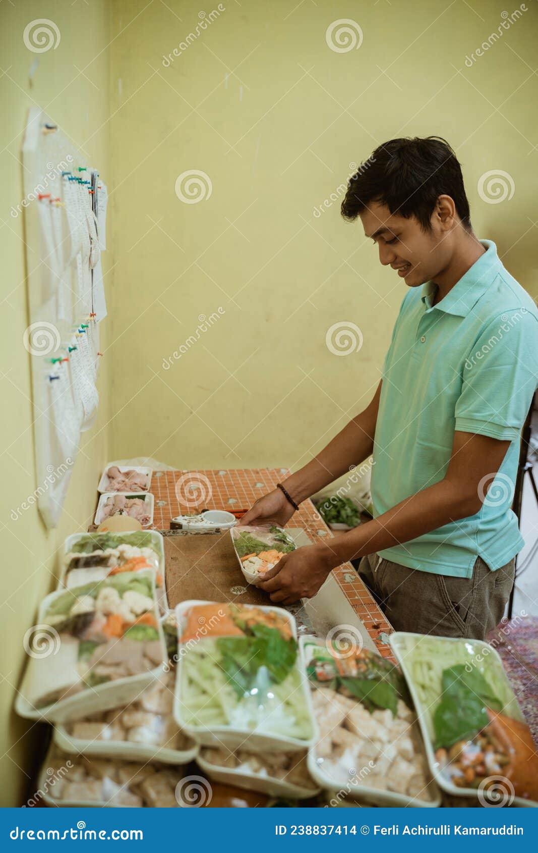 Asian Man Preparing Fresh Vegetables Using Plastic Wrap Stock Photo