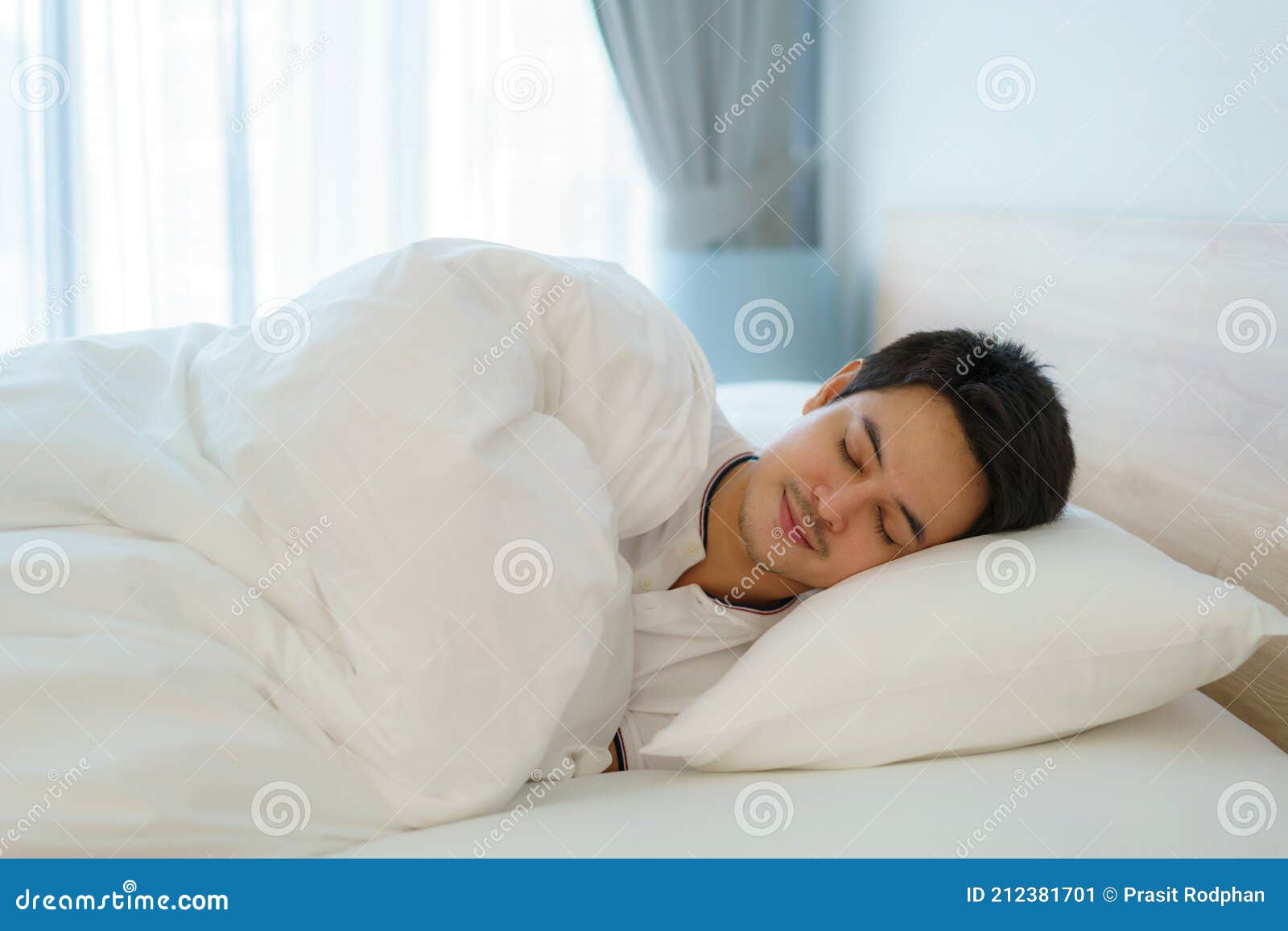 asian man are sleeping and having good dreams in white blanket in the morning. rest after work tiring in bedroom at home