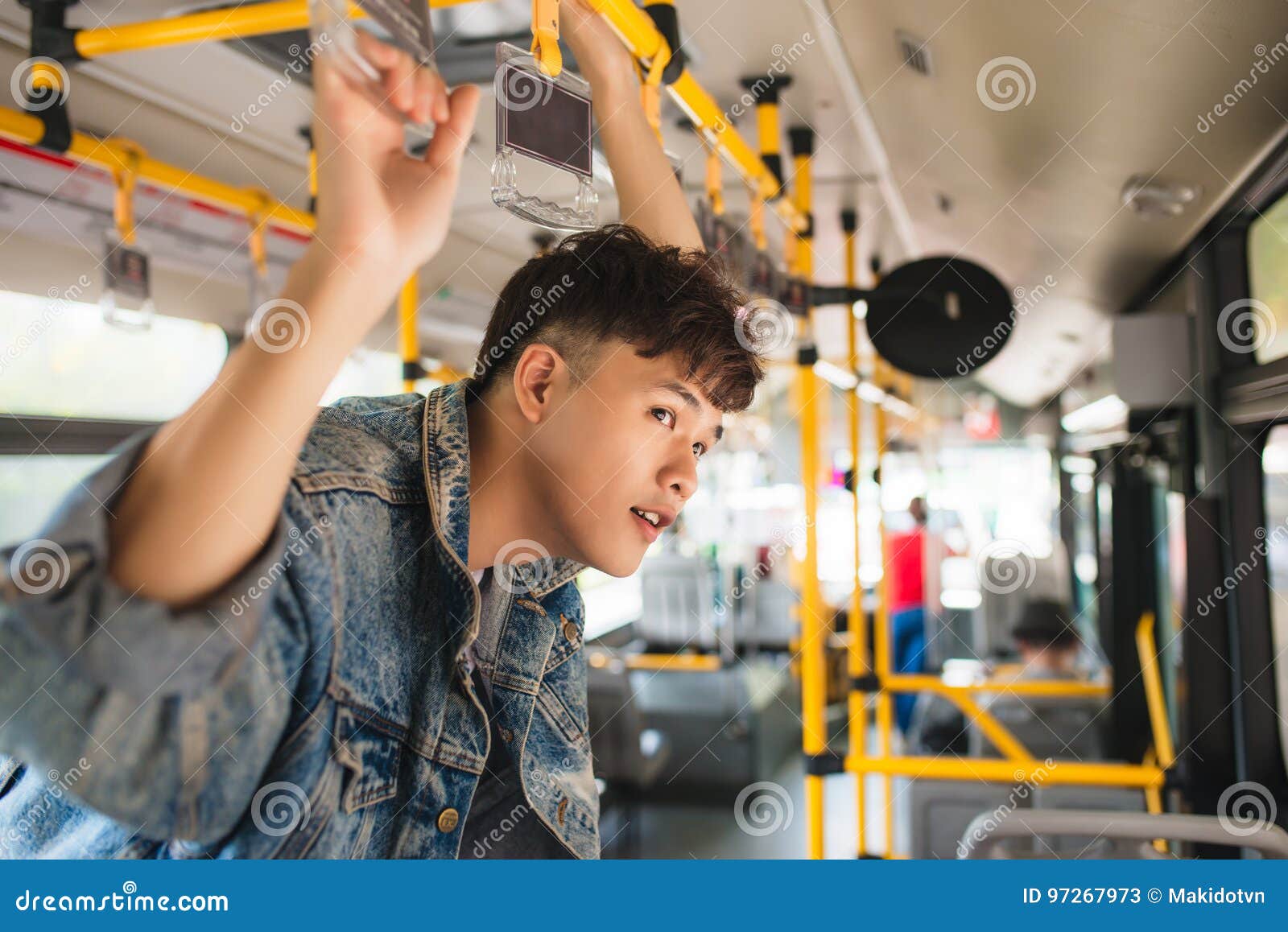 Asian Man Taking Public Transport Standing Inside Bus