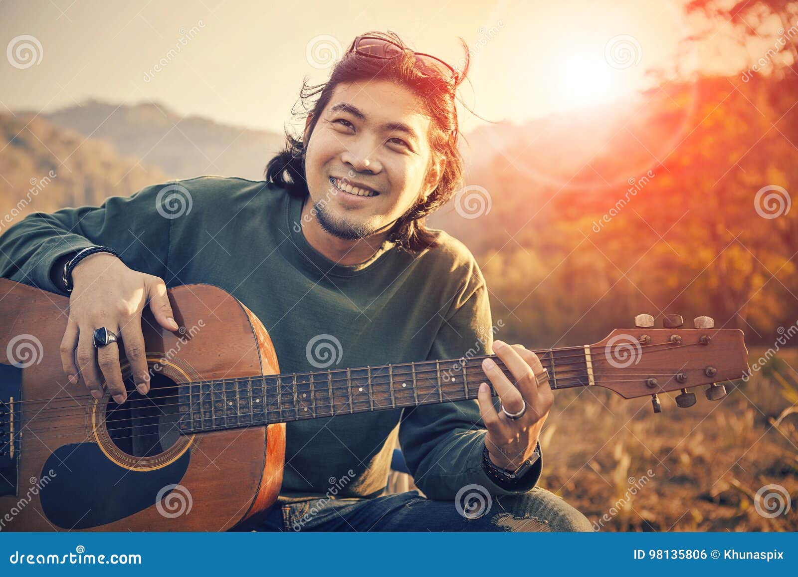 asian man toothy smiling face with happiness playing guitar and