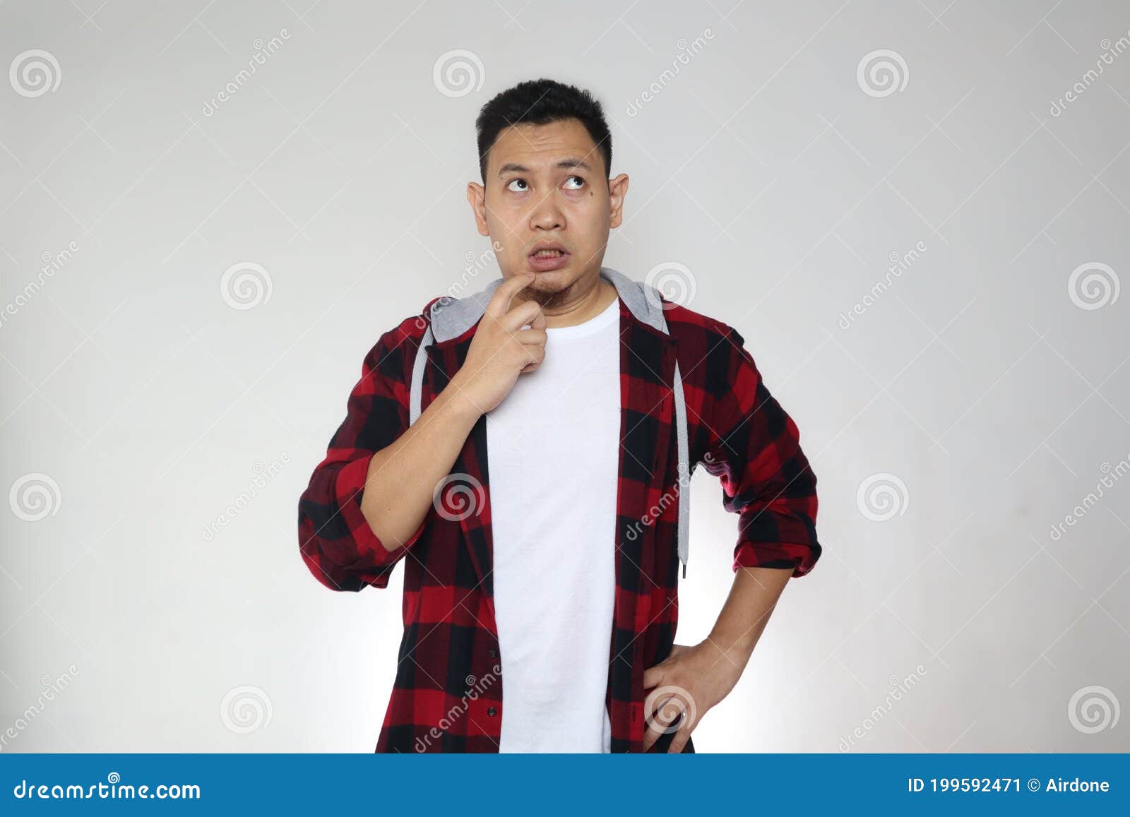 asian man touching his lip with pointing finger, looking up and thinking hard, trying to remember gesture