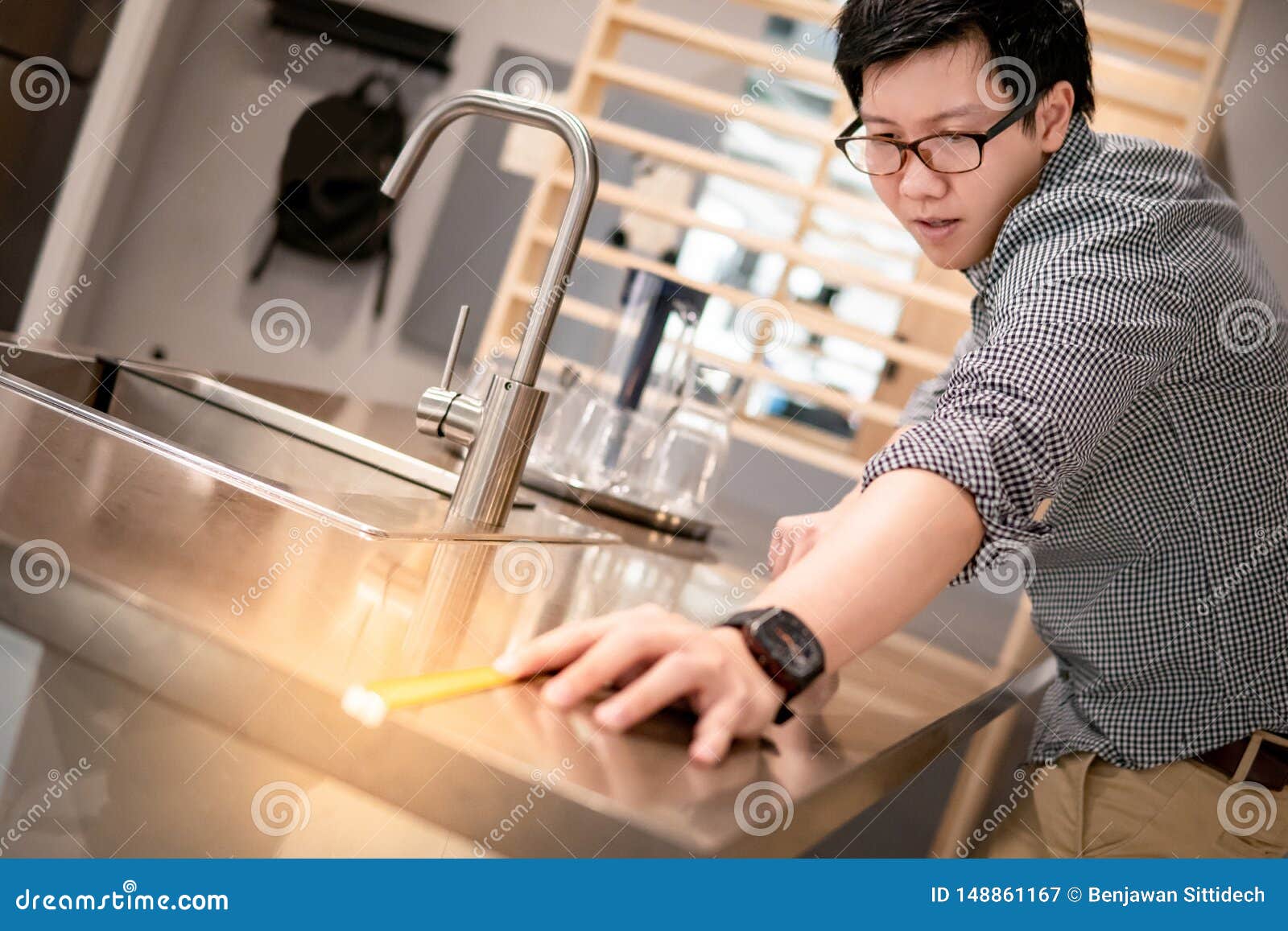 Asian Man Using Tape Measure On Kitchen Counter Stock Image