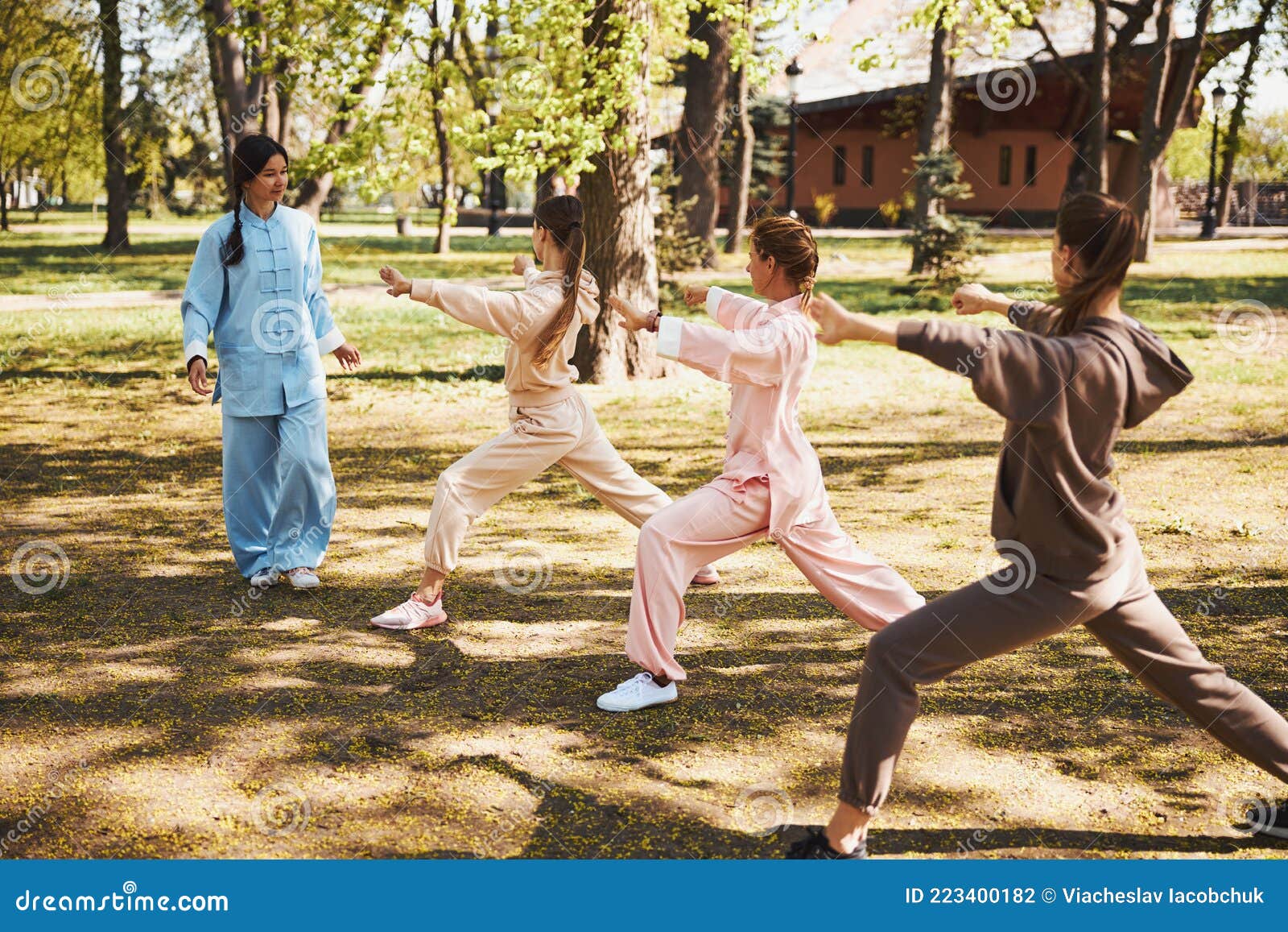 Tai Chi Instructor Checking the Postures of Her Students Stock Photo