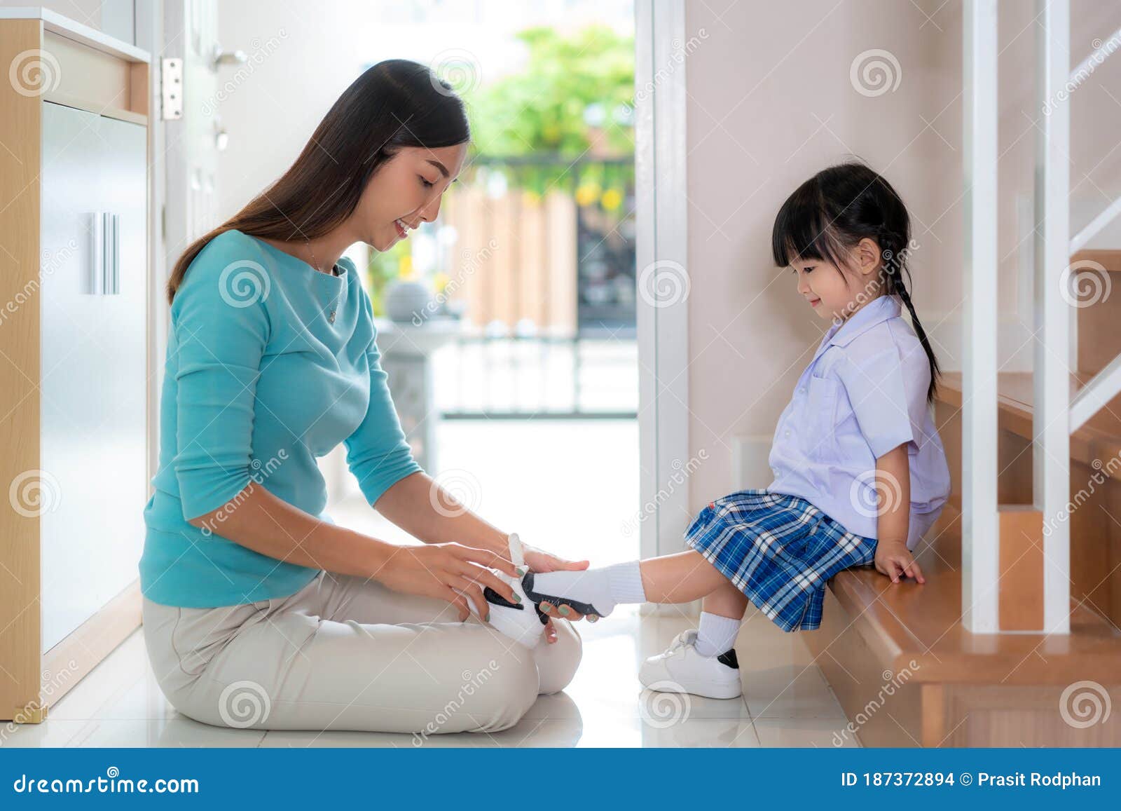 Asian Mother Helping Her Daughter Put Shoes on or Take Off at Home Getting  Ready To Go Out Together or Coming Back Home from Stock Photo - Image of  parenting, lifestyle: 187372894