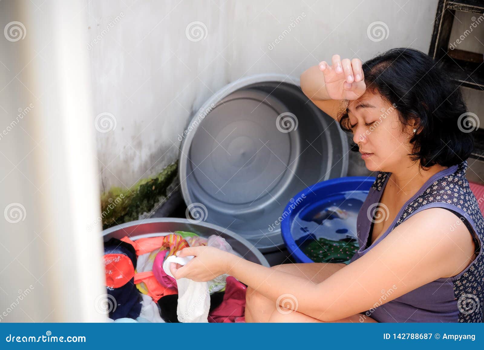 Asian Mother Looking Tired Hand Washing Laundry At Home Stock Image