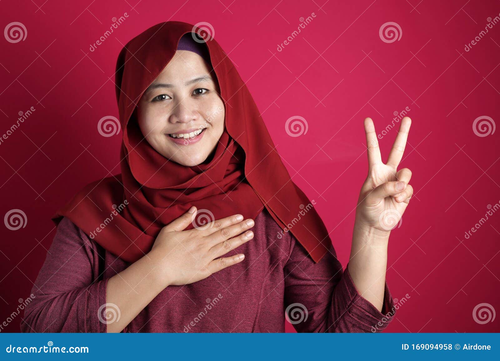asian muslim woman making pledge gesture, hand on chest, making promise