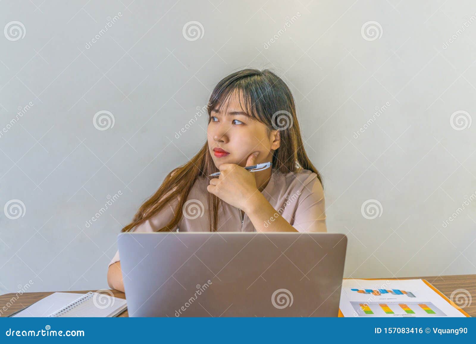 Asian Office Lady Distracted and Thinking while Working on Laptop