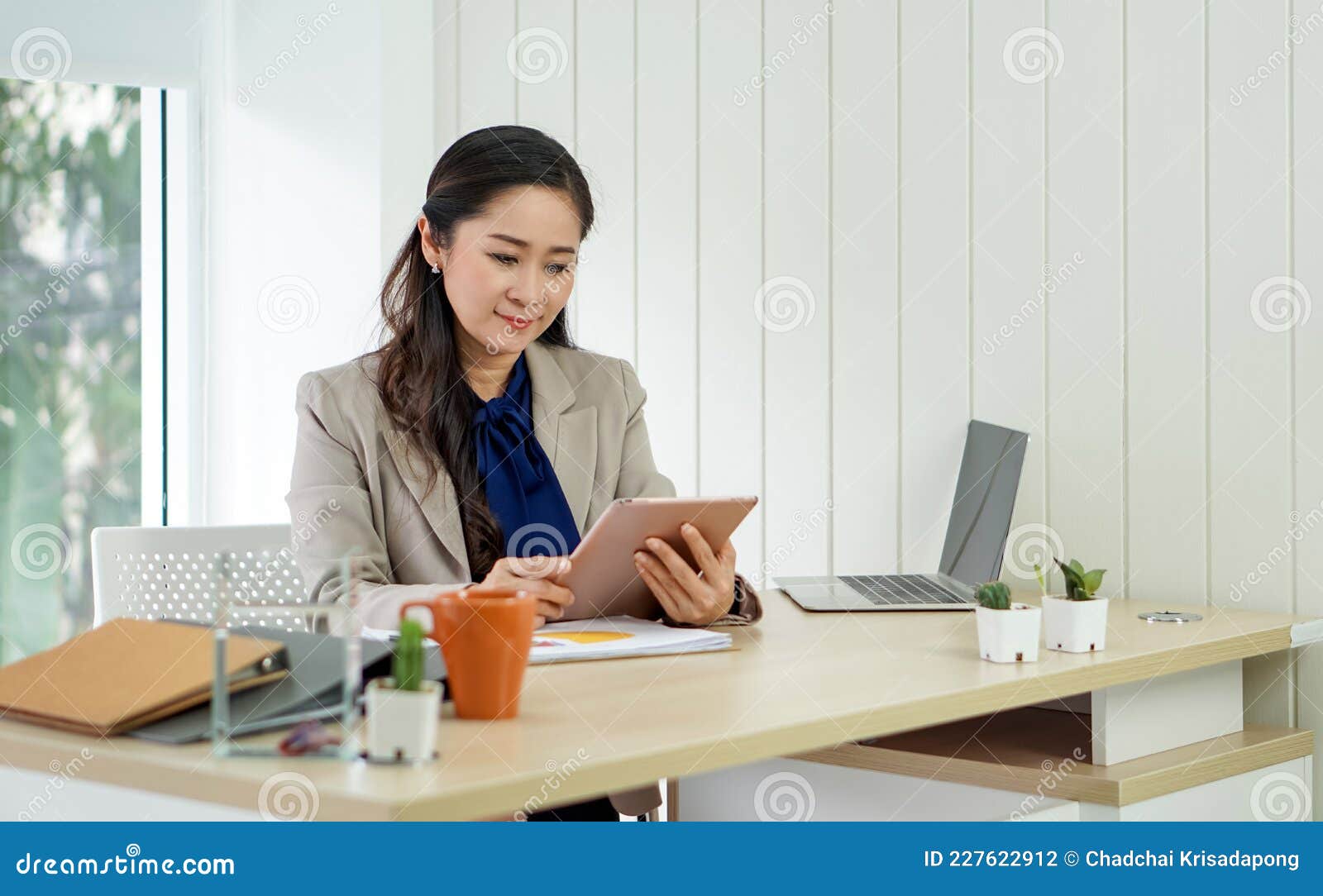 Asian Office Manager with Brown Suit Holding Tablet Computer in Her ...