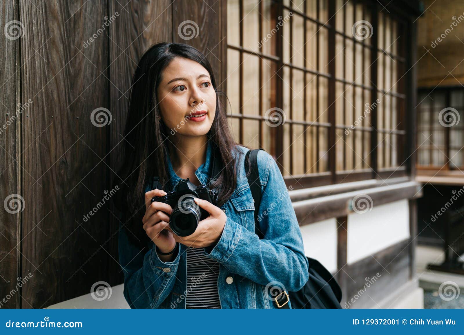 asian photographer relying on the wooden wall