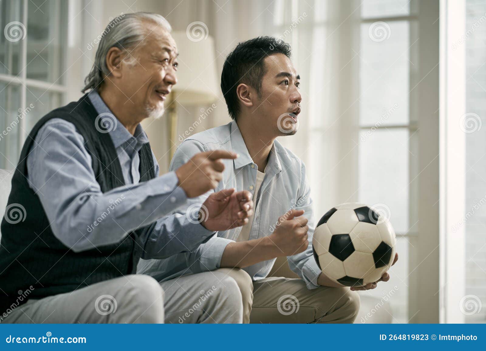 Asian Senior Father and Adult Son Watching Football Match on Tv Together Stock Image