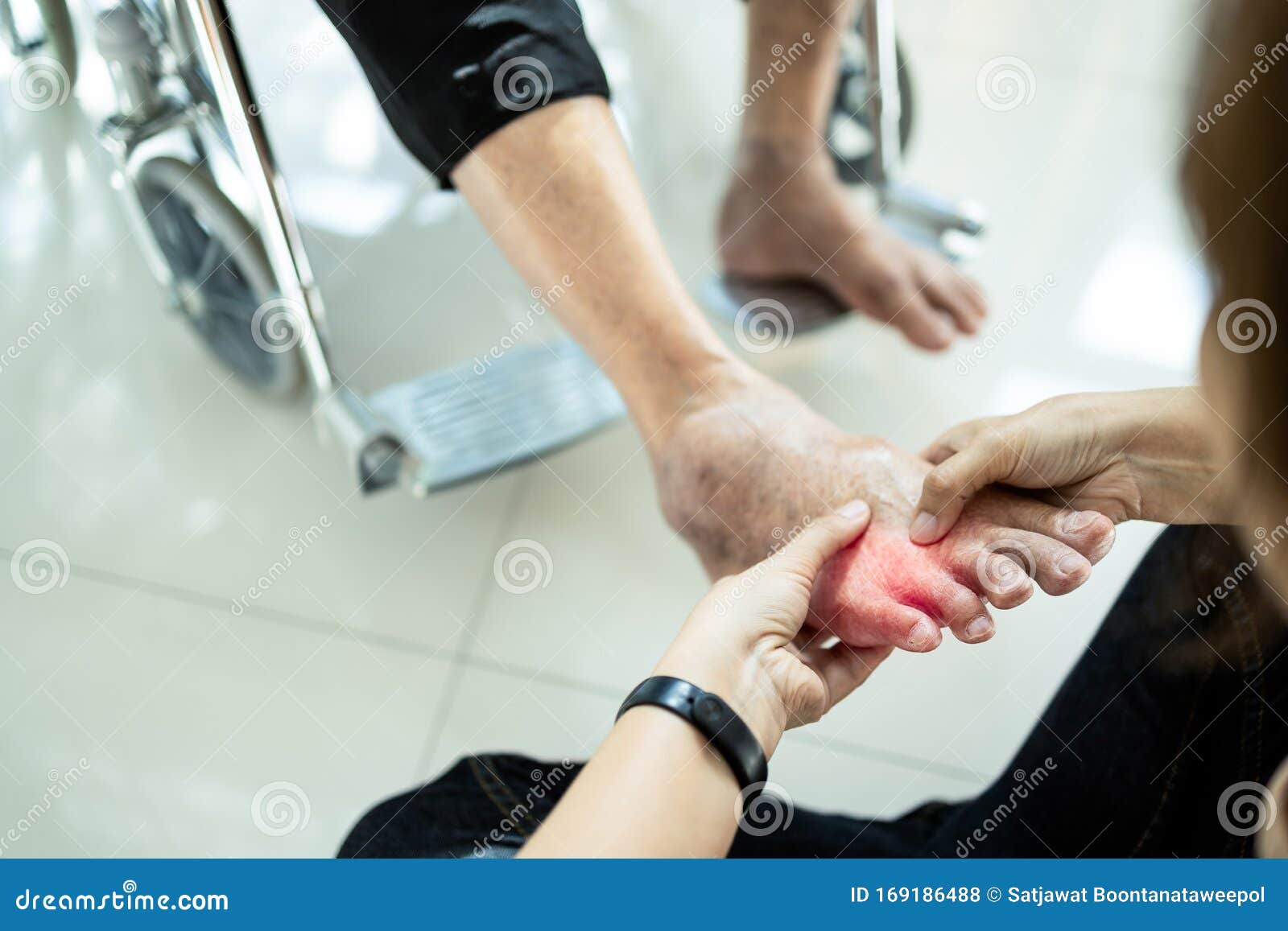 asian senior mother in wheelchair,receiving a foot massage from her daughter,physiology pressing with fingers to relax,old woman