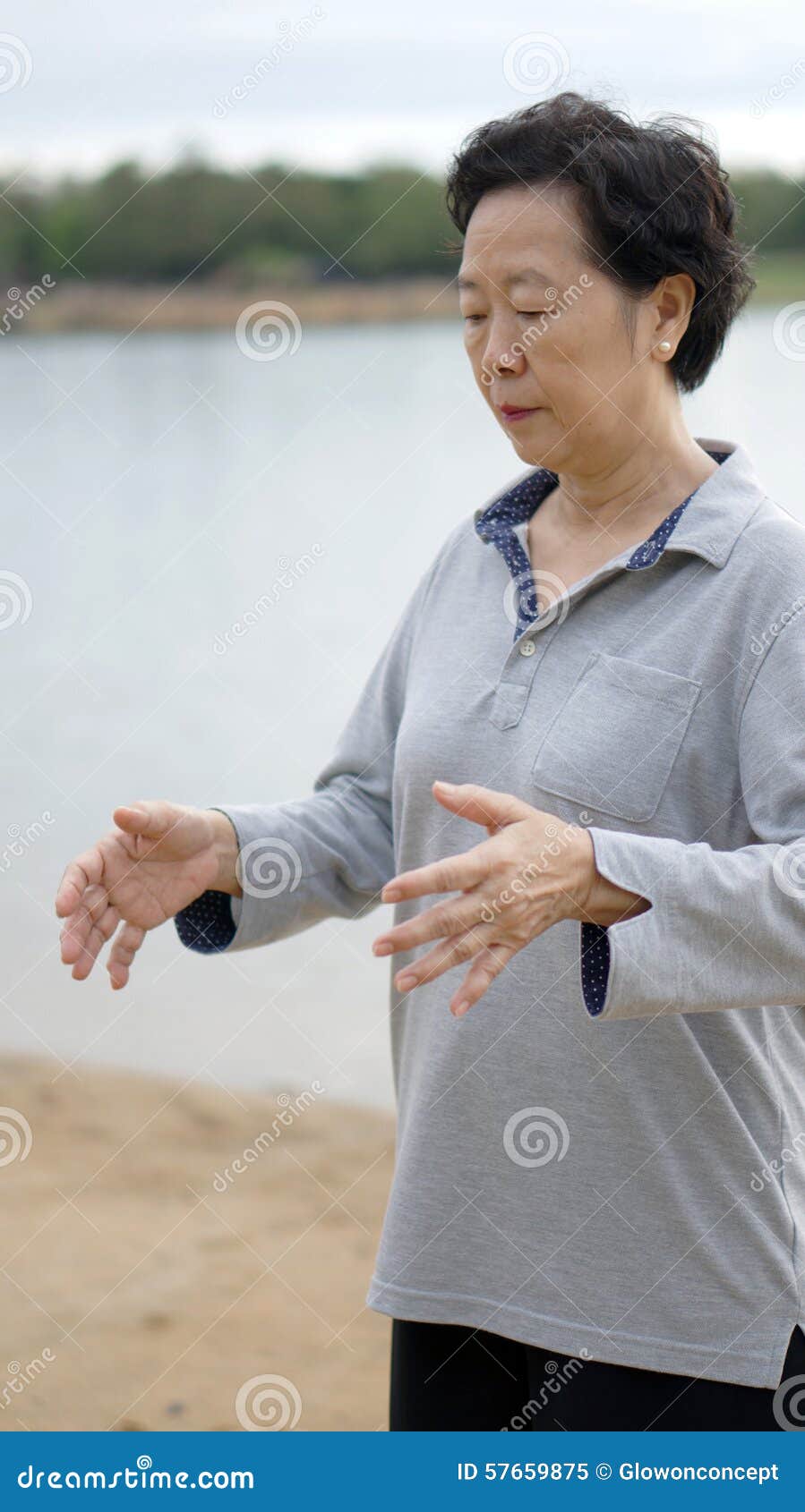 Asian Senior Practice Taichi, Qi Gong exercise outdoor next to the lake