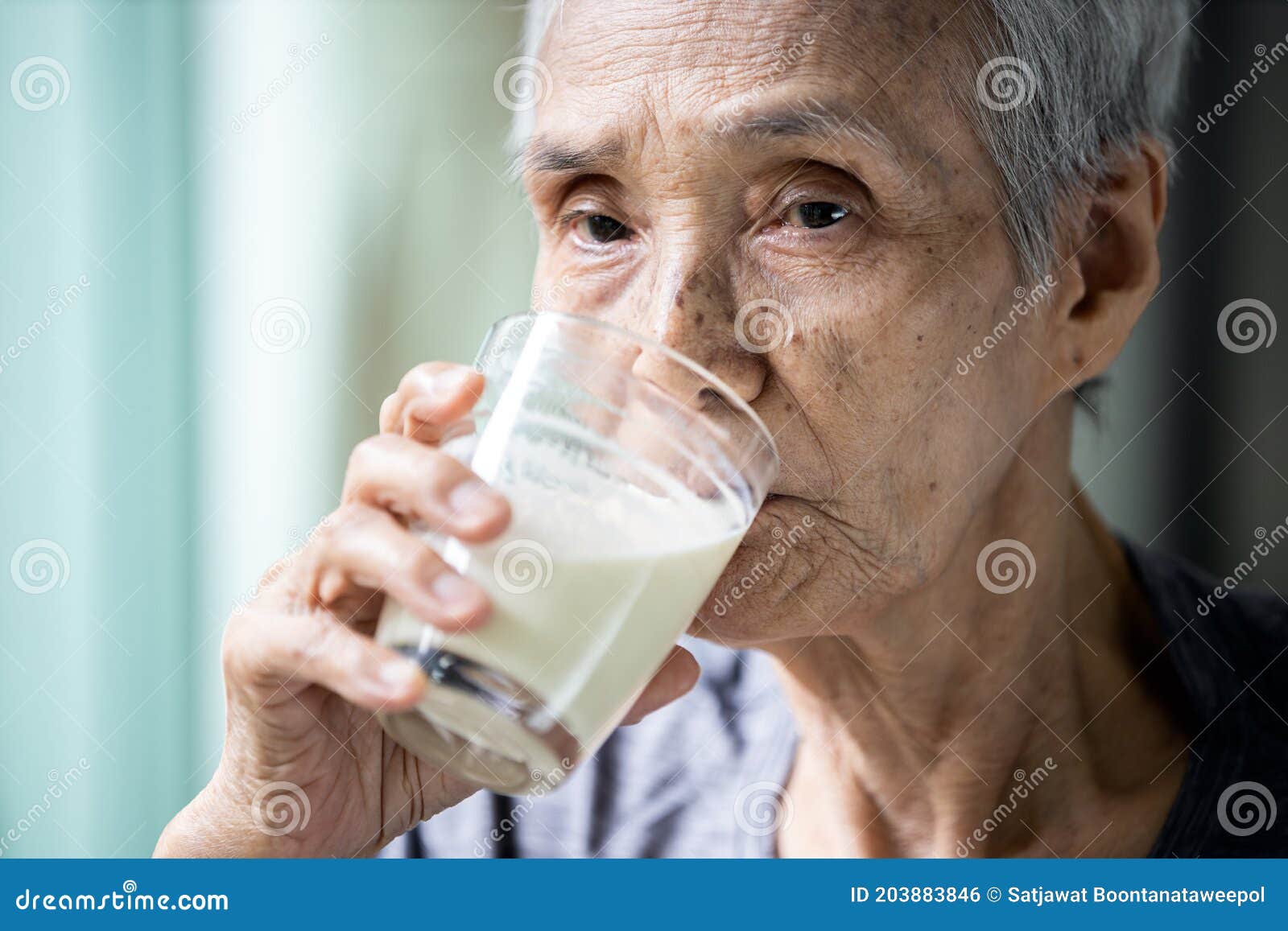 asian senior woman drinking warm fresh milk from glass in the morning at home,old elderly eat foods that are beneficial to the