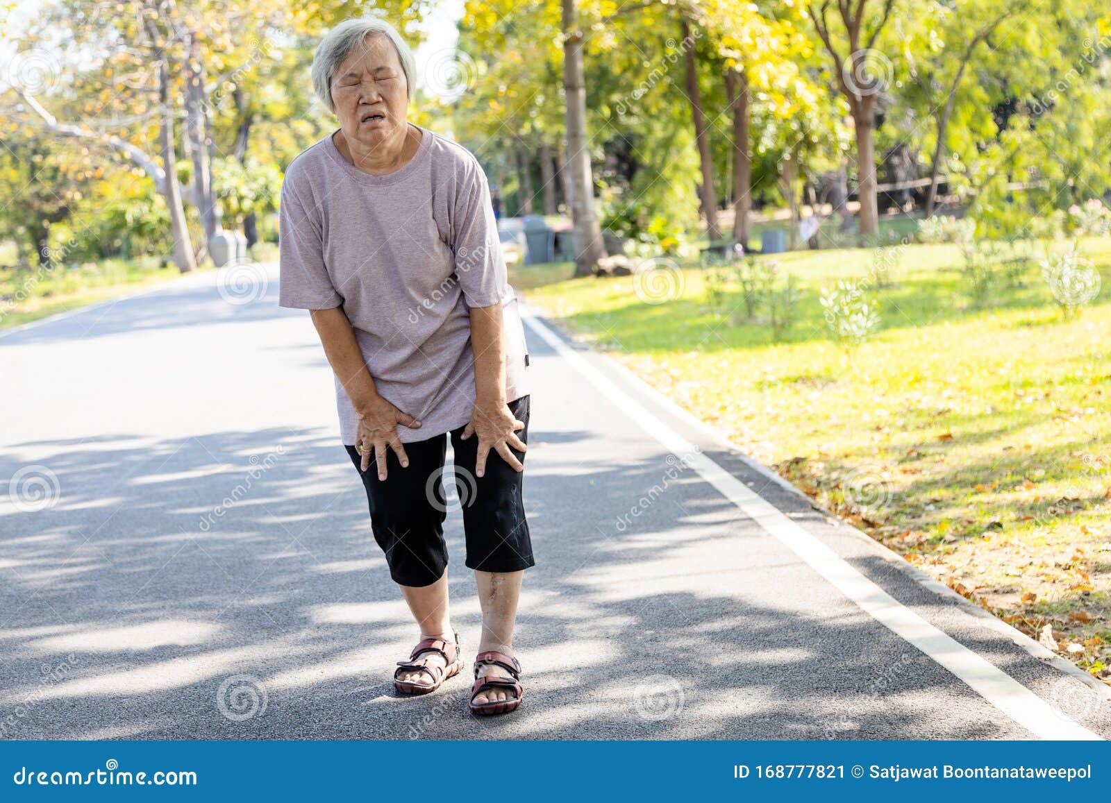 asian senior woman is extremely tired while walking at park, body is weak feeling tired easily due to lack of energy and donÃ¢â¬â¢t