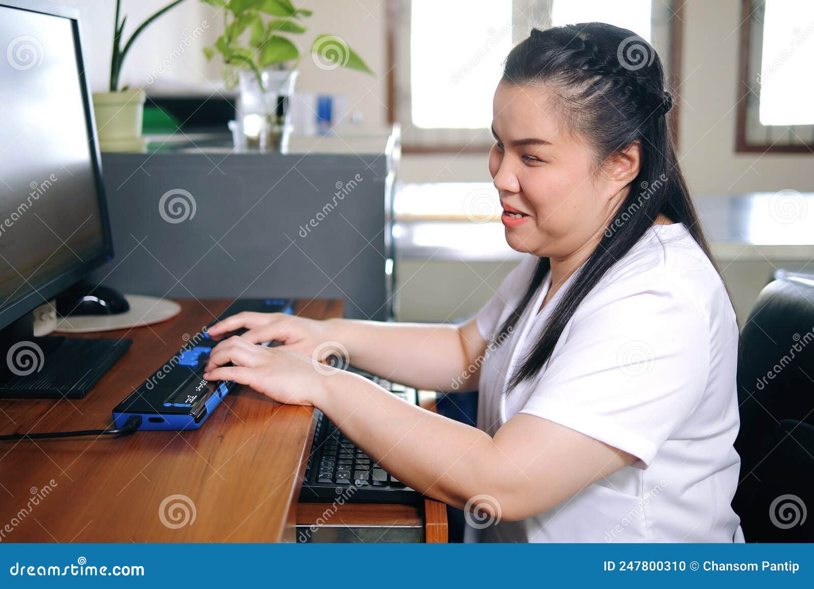 Asian Woman with Blindness Disability Using Computer with Refreshable