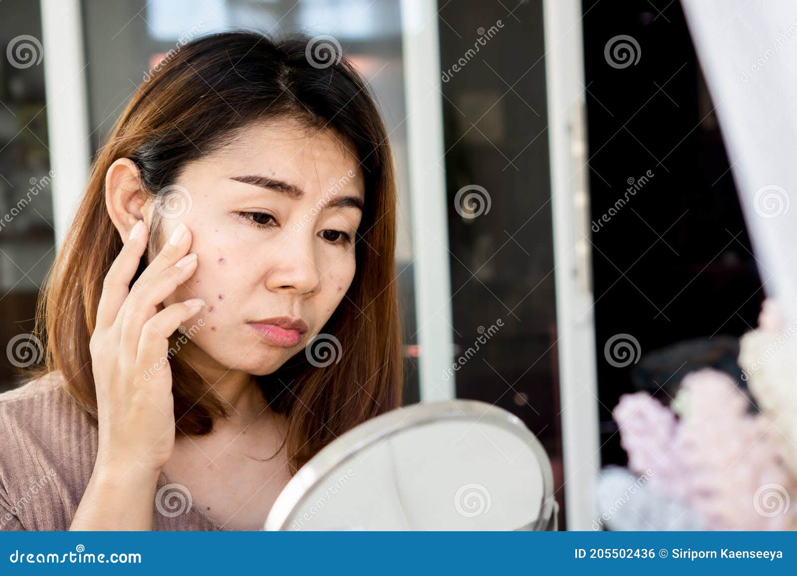 asian woman checking her face skin problem with acne scar, dark spot on mirror