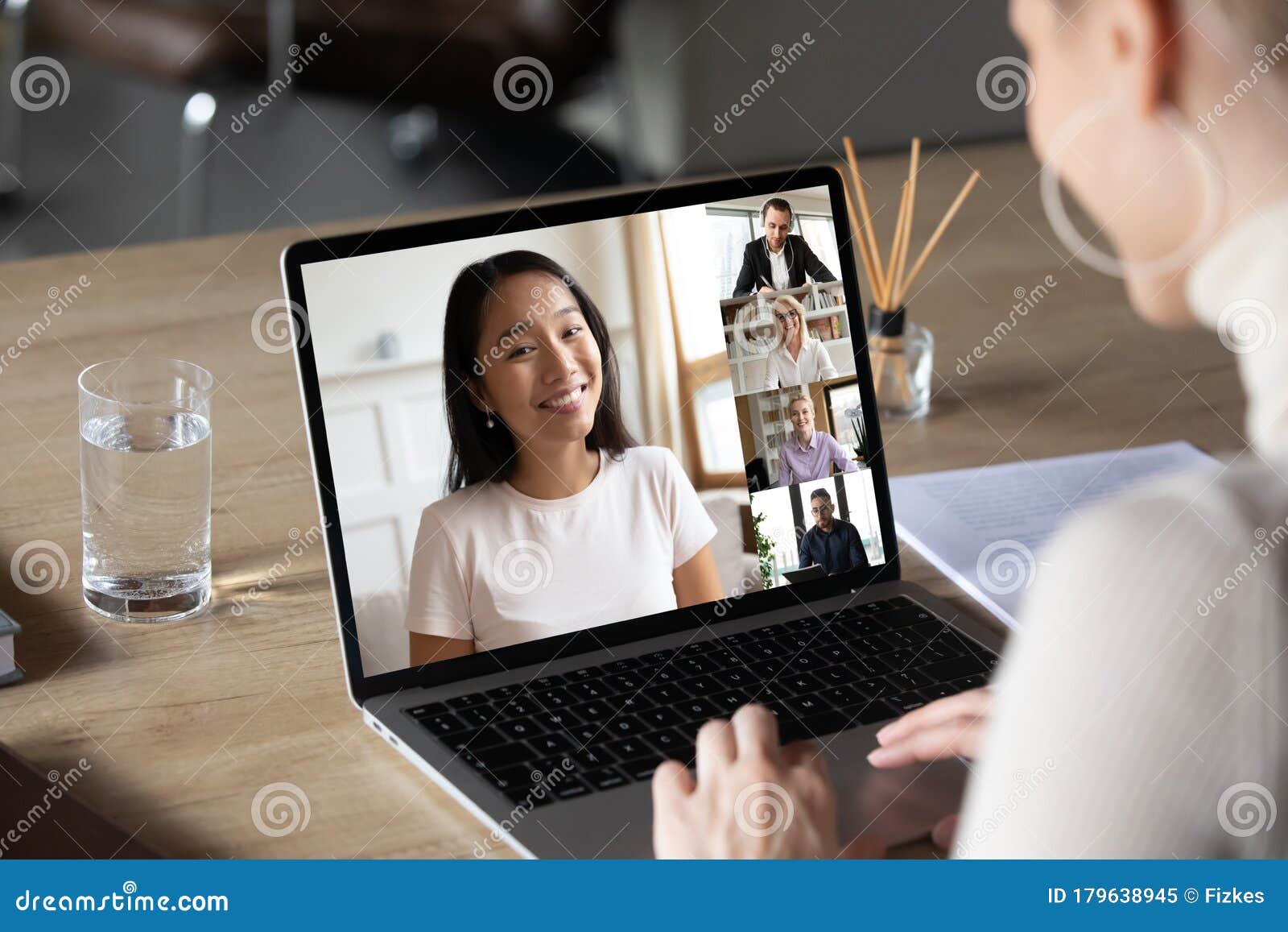 asian woman and diverse colleagues taking part in group videocall