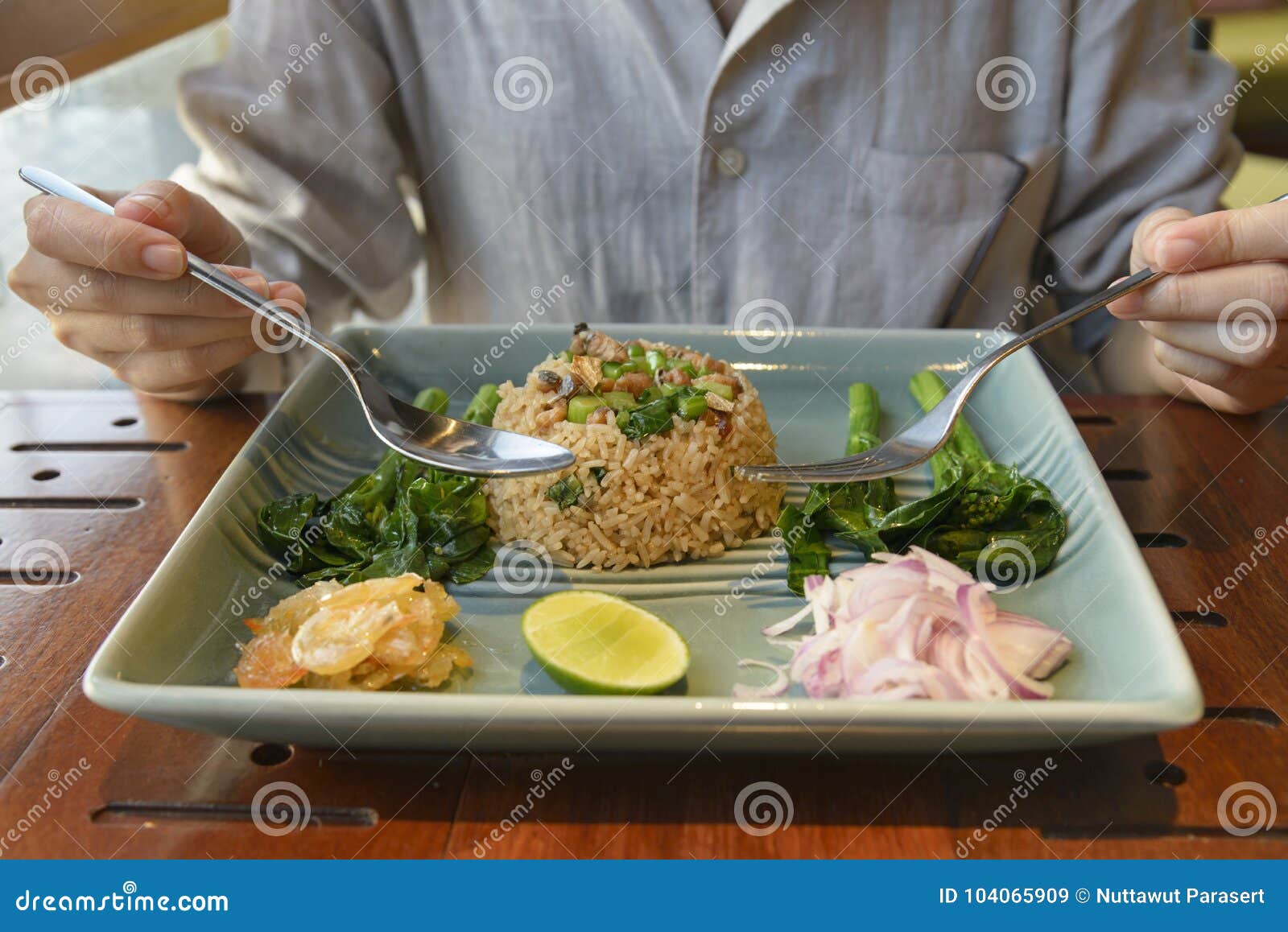 Asian Woman Eating Fried Rice with Salted Fish and Side Dish of Stock