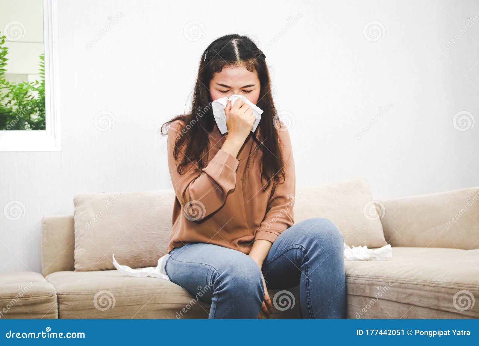 An Asian Woman Has A Headache And A Runny Nose Sitting On The Sofa In 