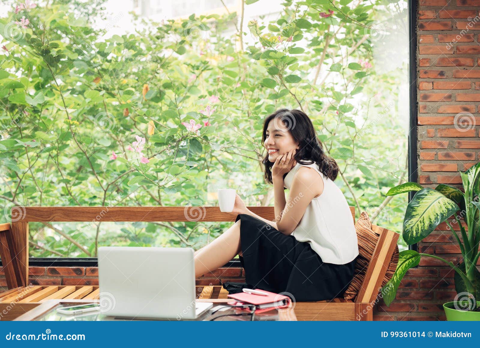 Asian Woman Holding Coffee Cup while Sitting Near Window in Creative ...