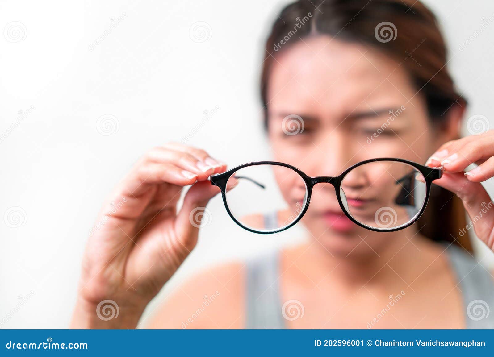 asian woman holding glasses on white background, selective focus on glasses , myopia and eyesight problem concept