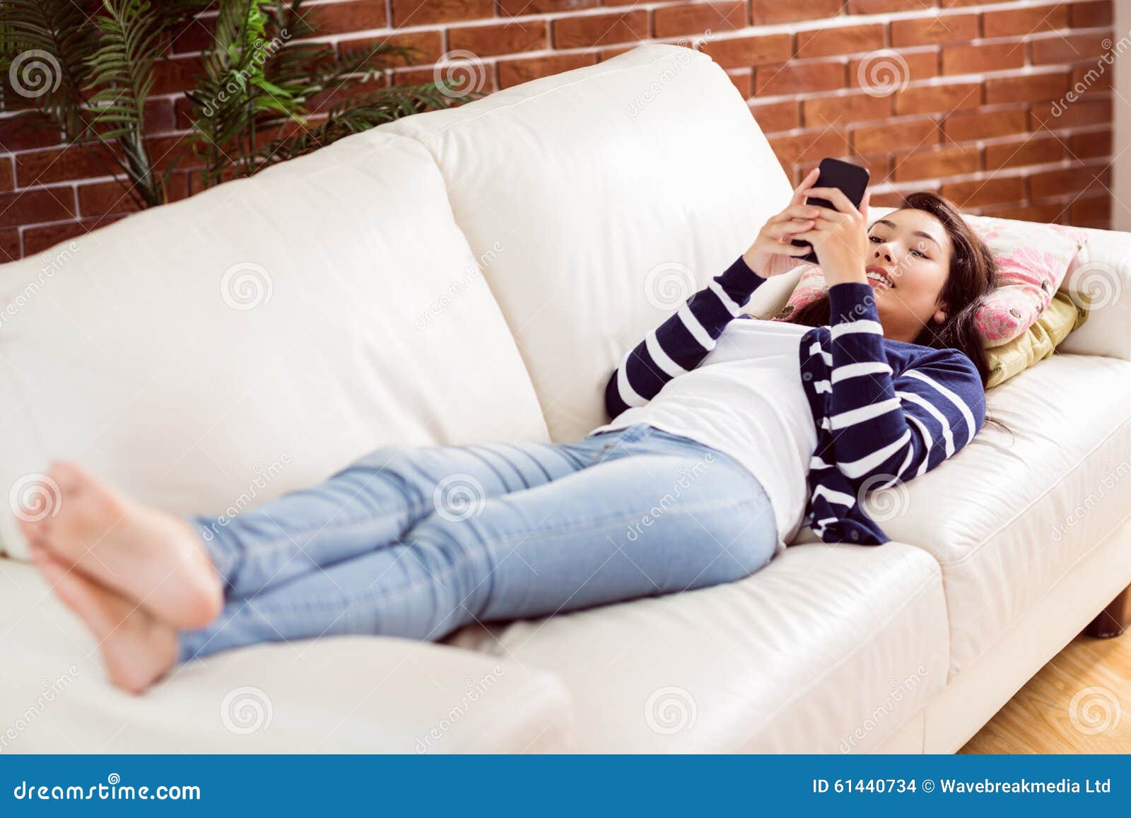 Asian Woman Lying On The Couch Using Phone Stock Photo Image Of