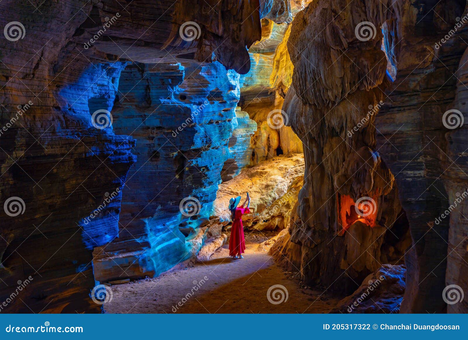 asian woman in a pink dress visits a blue cave in tak province, thailand