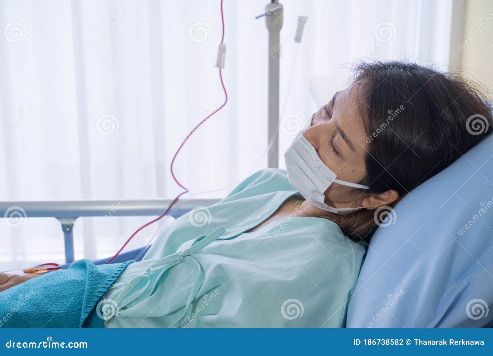 asian woman is sick has a high fever, sneezing, is recuperating in the patient`s dress lay on the patient bed in the hospital wit